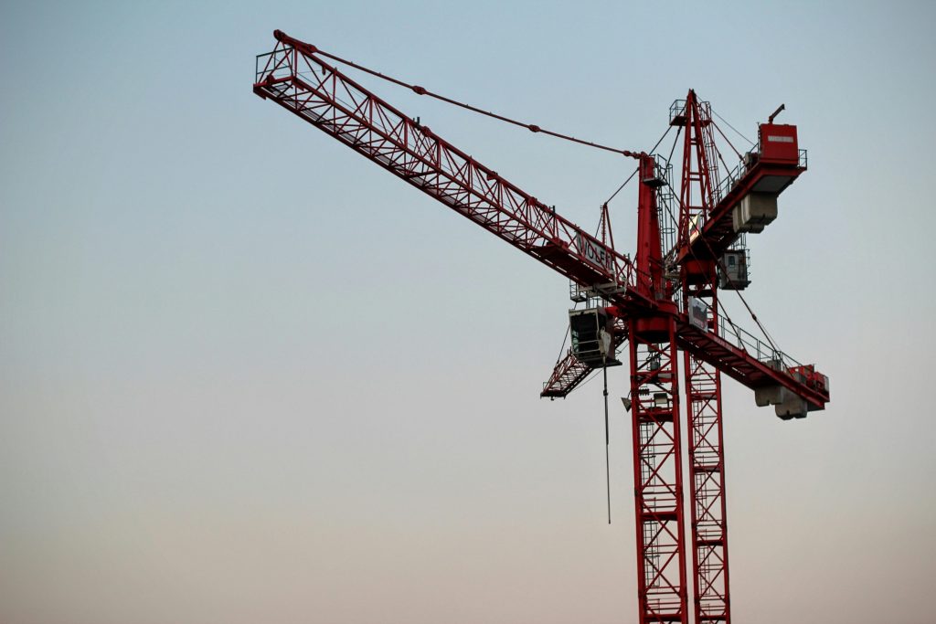 pexels photo 209272 209272 A red tower crane on a construction site set against a clear sky during daytime.